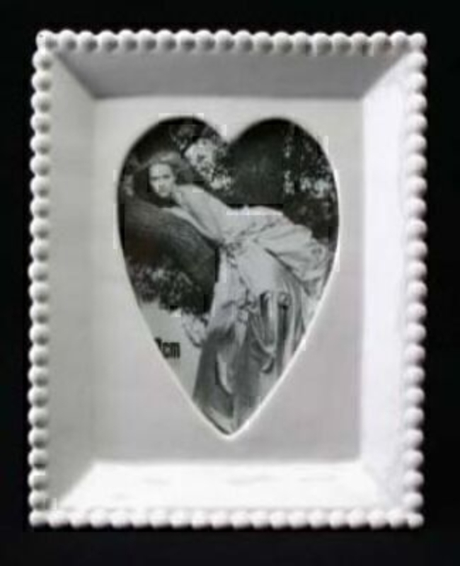 White ceramic photo frame with 'beaded' design edge and heart shaped aperture for your photo.  Holds photo size 12x9cm Frame size 17x14cm